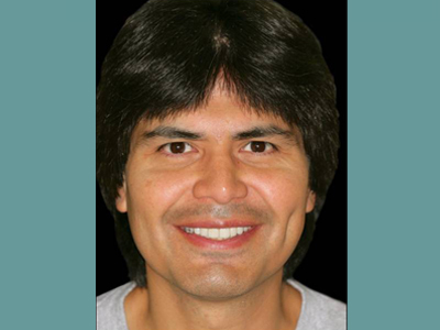 The image features a man with a mustache and short hair, wearing a light-colored shirt. He is smiling at the camera.