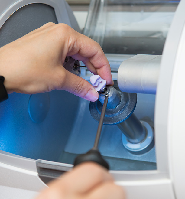 The image shows a person using a machine with a blue light, focusing on the operation of the device.