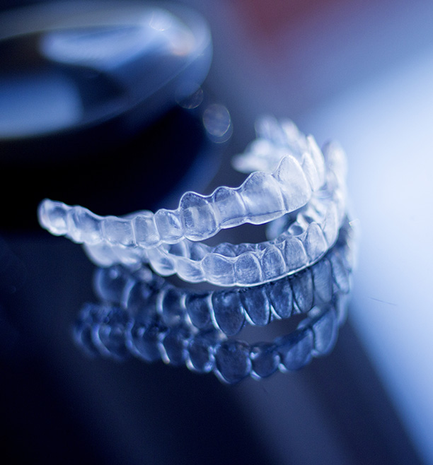 Clear plastic braces on a reflective surface, showcasing their transparency and design.