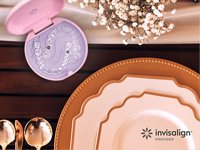 The image features a collection of tableware, including plates and a decorative piece, arranged on a wooden surface with a pink box in the center.