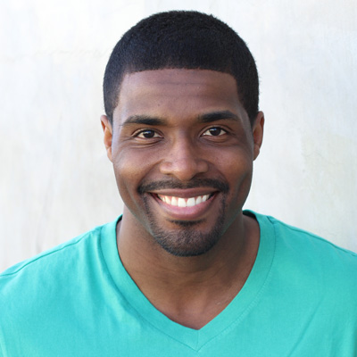 An elderly couple sharing a joyful moment together, with the man wearing a beard and both of them smiling.